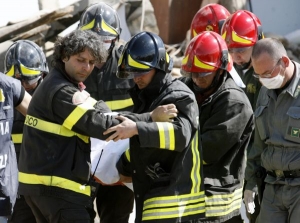 Záchranáři vytahují tělo z trosek.